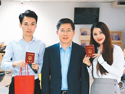 中国驻泰国大使吕健(中)为一对新人颁发结婚证书.