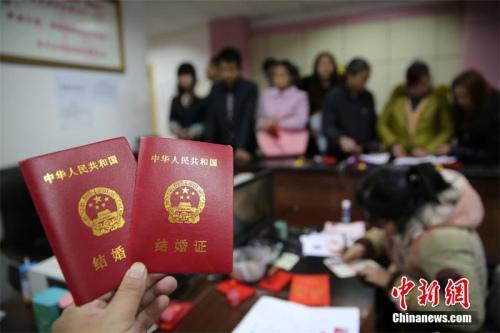 在四川省内江市东兴区婚姻登记处,新人在展示刚领取的结婚证书